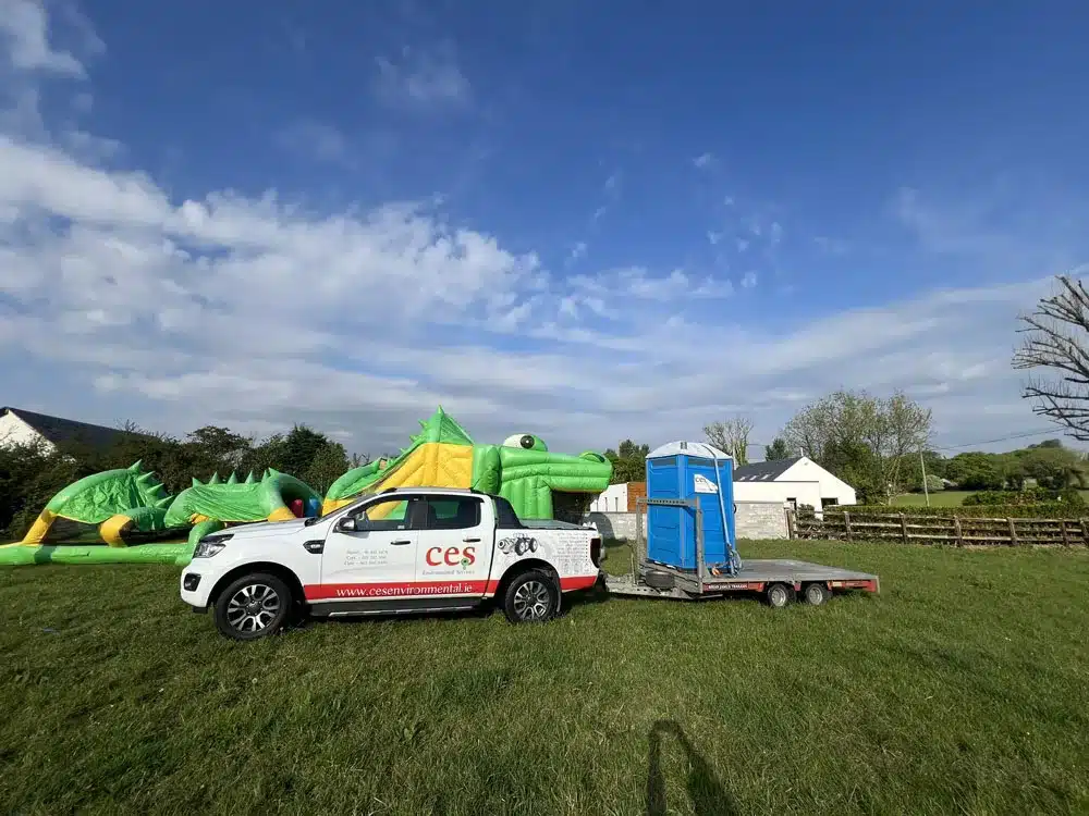 portable toilet party hire with bouncy castle in background